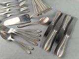 many spoons and forks laid out on the table