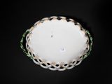 a white bowl with a green and gold decoration on it