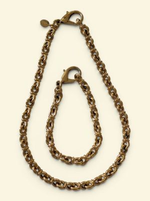 a close up of a necklace and a chain on a white background