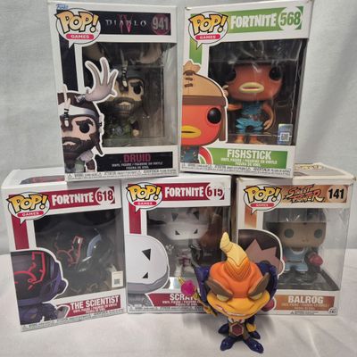 cinq figurines Funko de différentes tailles et couleurs sont posées sur une table
