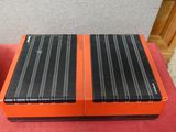 deux enceintes posées sur une table rouge à côté d'un tourne-disque