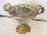 a gold vase with a colorful design on it on a table