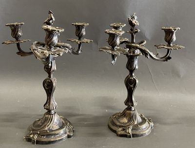 deux chandeliers en argent posés sur une table