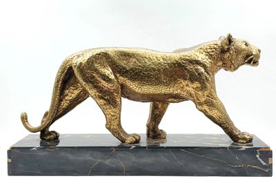 statue d'un lion doré posée sur un socle en marbre
