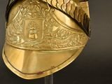 a gold helmet with a crest on it on a stand