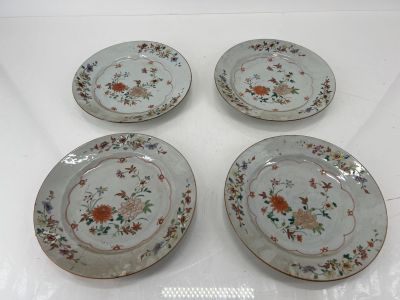four plates with floral designs on them sitting on a table