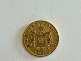 a close up of a gold coin on a white surface