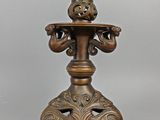 an antique bronze candle holder with a bird on top