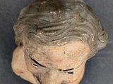 a close up of a head of a statue on a table