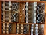a lot of forks and spoons in a wooden box