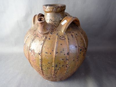 a brown vase that is sitting on a white surface