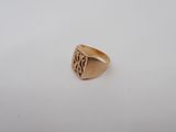 a gold signet ring with the initials of two people on it