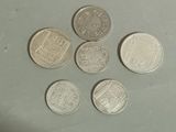 six different types of coins sitting on top of a white surface