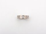 a close up of a ring with two diamonds on a white surface