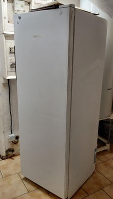 a white refrigerator sitting in the corner of a kitchen