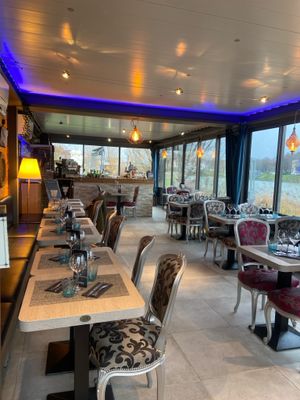 des tables et des chaises dans un restaurant avec vue sur l'eau