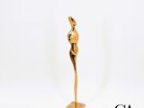 une statue en or représentant une femme debout sur un socle en bois