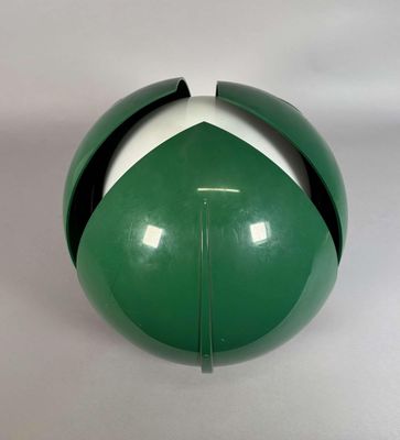 une boule verte et blanche posée sur une surface blanche