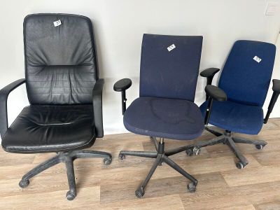 Trois chaises de bureau sont alignées contre un mur dans une pièce