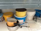 many buckets and pans sitting on a counter