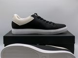 a pair of black and white sneakers sitting on top of a black box
