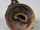 a bronze vase that has a hole in it