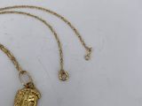 an image of a gold necklace with a face of jesus on it