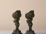 pair of antique bronze candlesticks on a white table