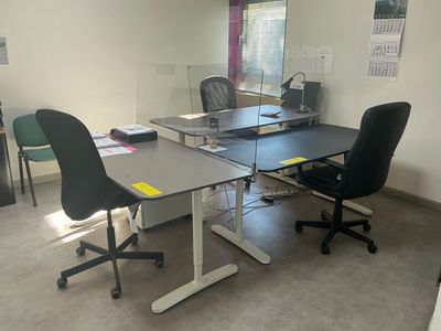 two desks and chairs in a room with a window