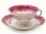 purple and gold tea cup and saucer on a white background