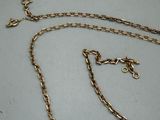a close up of a gold chain on a white surface