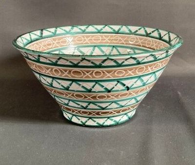 a green and white bowl sitting on a table