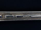 a close up of a silver spoon on a black surface