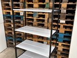 a close up of a shelf in a warehouse with pallets in the background