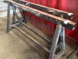 a large metal bench in a garage with a red curtain in the background