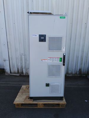 un réfrigérateur blanc posé sur une palette devant un immeuble