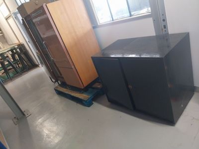 two black cabinets in a room next to a window