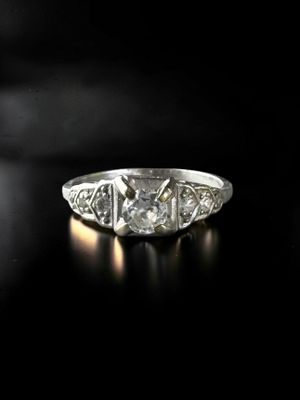 a close up of a diamond ring on a black surface