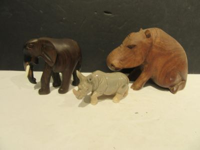 three wooden animals sitting next to each other on a table