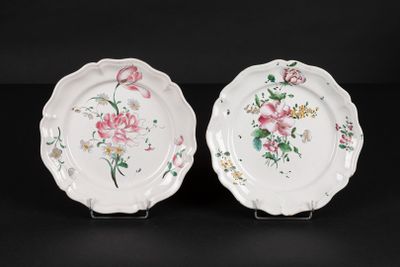 two white plates with pink flowers on them on a black surface