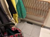a suitcase that is sitting on the floor next to a rack of clothes