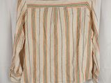 a striped shirt hanging on a hanger on a white curtain