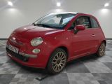 the small red car is parked on a checkered tile floor