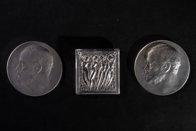 three different types of silver coins on a black surface
