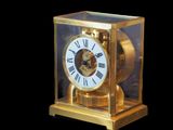 une horloge en or avec des chiffres romains, dans une vitrine