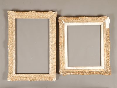 une paire de cadres photo anciens dorés accrochés au mur