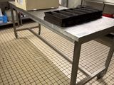 une grande table en métal sur laquelle est posé un plateau de nourriture