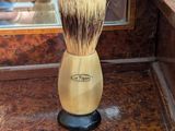a shaving brush sitting on top of a wooden counter