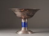 a silver cup with a blue handle sitting on a table