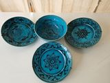 four small blue bowls with designs on them on a table